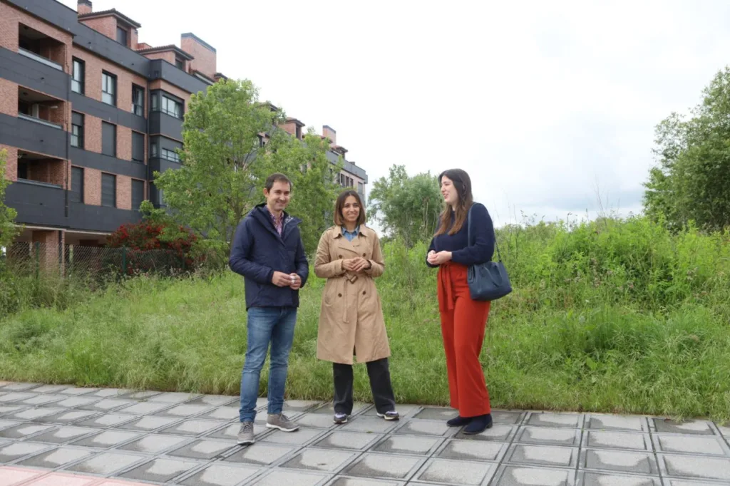 Representantes de Podemos Asturies delante de la parcela para vivienda pública en Asturias